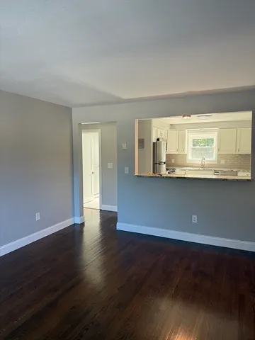 a view of a kitchen with wooden floor and a window