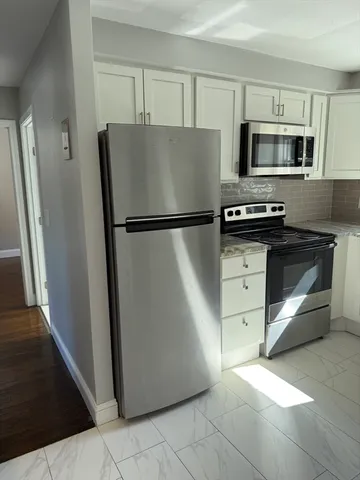 a white refrigerator freezer and a stove sitting inside of a kitchen