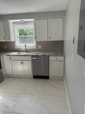 a kitchen with a stove sink and cabinets