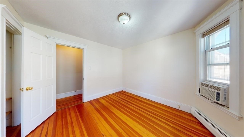 17 Gorham Road, Unit 2 Medford, MA 02155 - Photo 19 of 37 a view of an empty room with wooden floor and a window