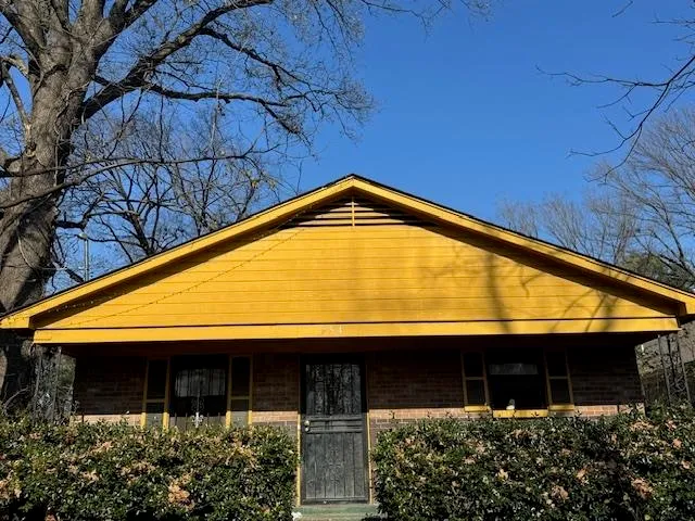 a view of small house with large windows and a small yard