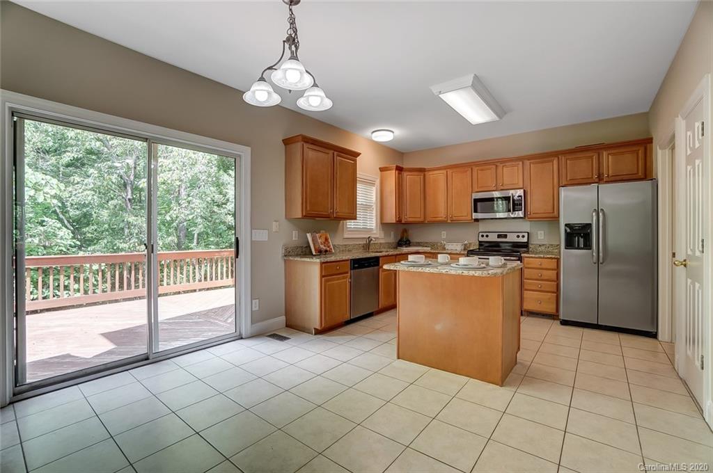 14010 Wild Elm Road Charlotte, NC 28277 - Photo 11 of 36 a kitchen with granite countertop a refrigerator a stove top oven cabinets a sink and a large window
