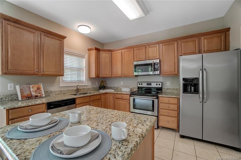 14010 Wild Elm Road Charlotte, NC 28277 - Photo 12 of 36 a kitchen with stainless steel appliances granite countertop a sink a stove a refrigerator and cabinets