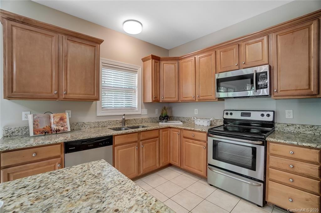 14010 Wild Elm Road Charlotte, NC 28277 - Photo 13 of 36 a kitchen with stainless steel appliances granite countertop a stove sink microwave and cabinets