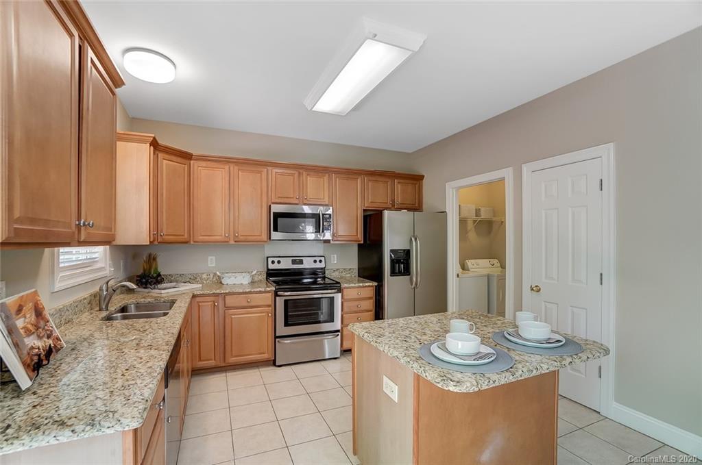 14010 Wild Elm Road Charlotte, NC 28277 - Photo 14 of 36 a kitchen with stainless steel appliances granite countertop a sink stove refrigerator and cabinets