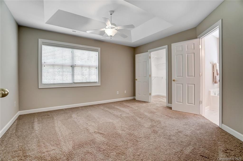 14010 Wild Elm Road Charlotte, NC 28277 - Photo 21 of 36 an empty room with chandelier fan and windows