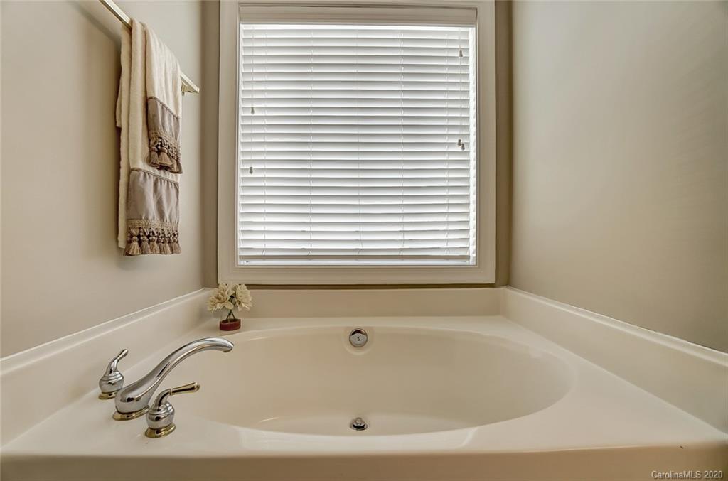 14010 Wild Elm Road Charlotte, NC 28277 - Photo 25 of 36 a white bath tub sitting in a bathroom next to a window