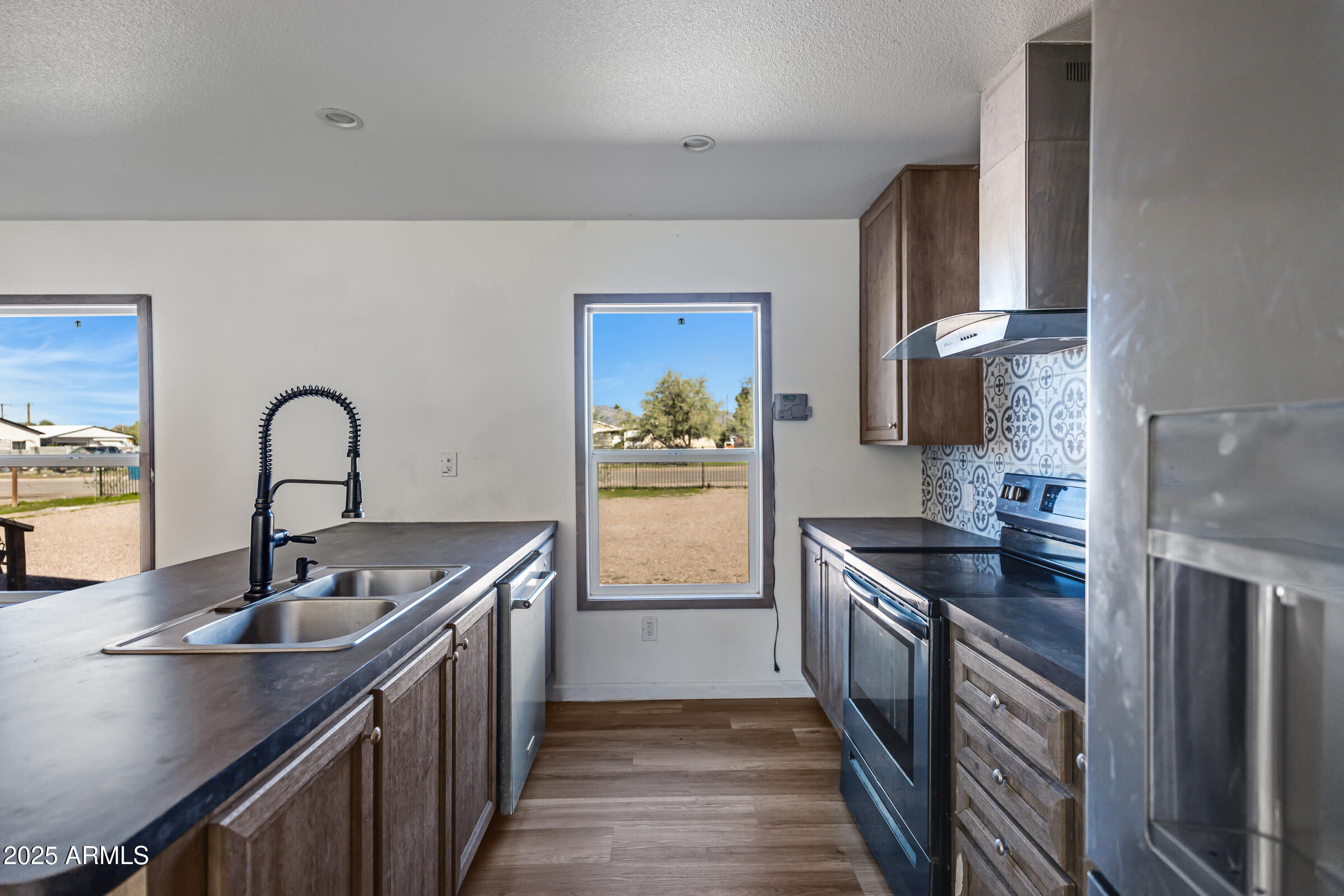 11341 East 6th Avenue Apache Junction, AZ 85120 - Photo 12 of 37 a kitchen with stainless steel appliances granite countertop a sink stove and refrigerator