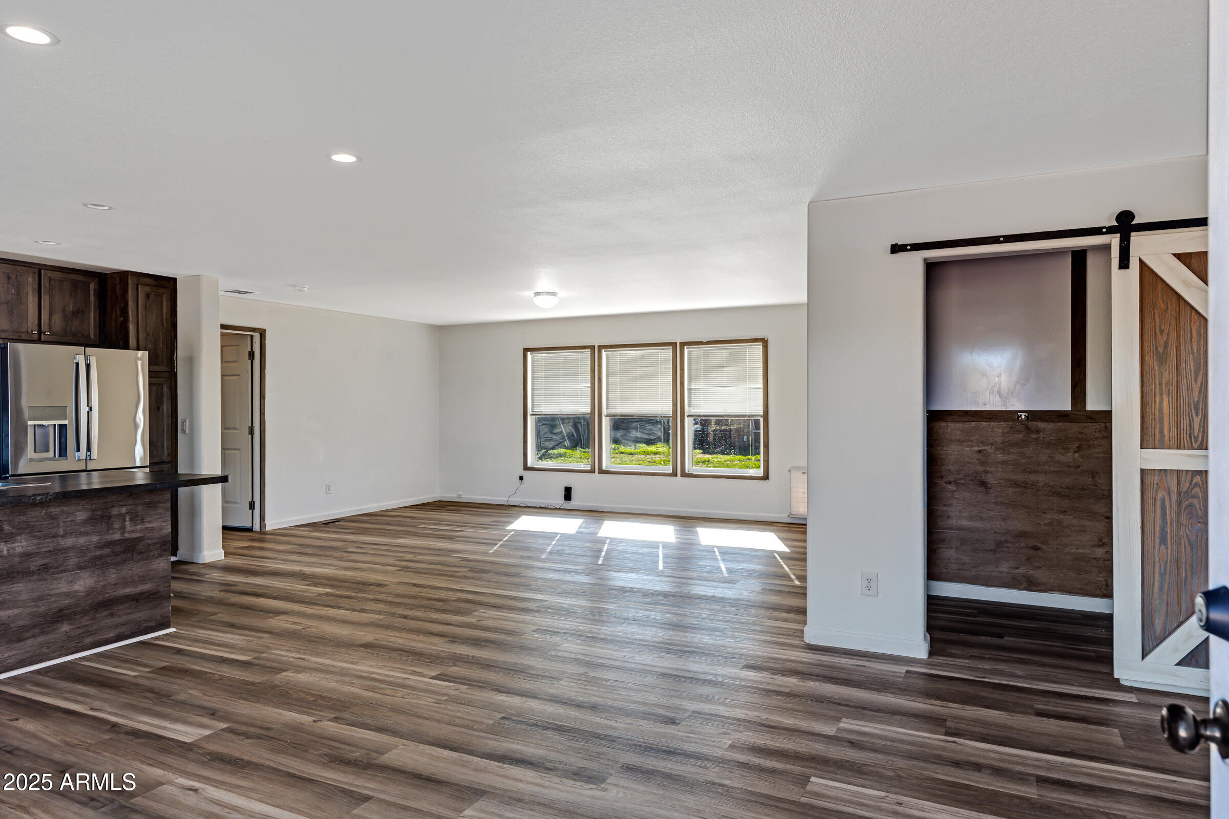11341 East 6th Avenue Apache Junction, AZ 85120 - Photo 4 of 37 a view of an empty room with wooden floor and a window