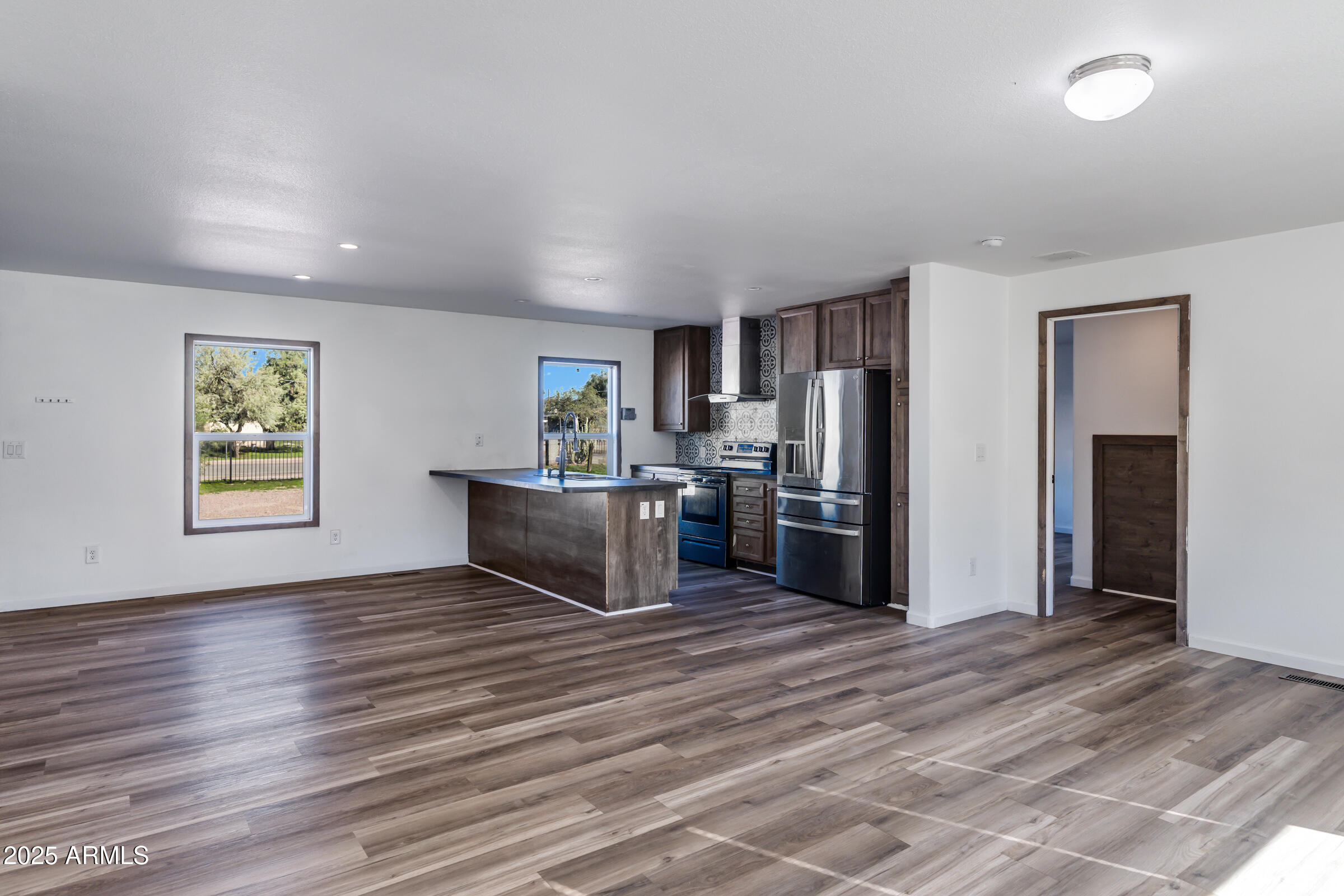 11341 East 6th Avenue Apache Junction, AZ 85120 - Photo 8 of 37 a kitchen with stainless steel appliances a refrigerator and a wooden floor