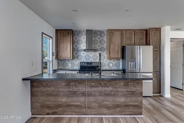 a kitchen with stainless steel appliances granite countertop a sink stove and refrigerator