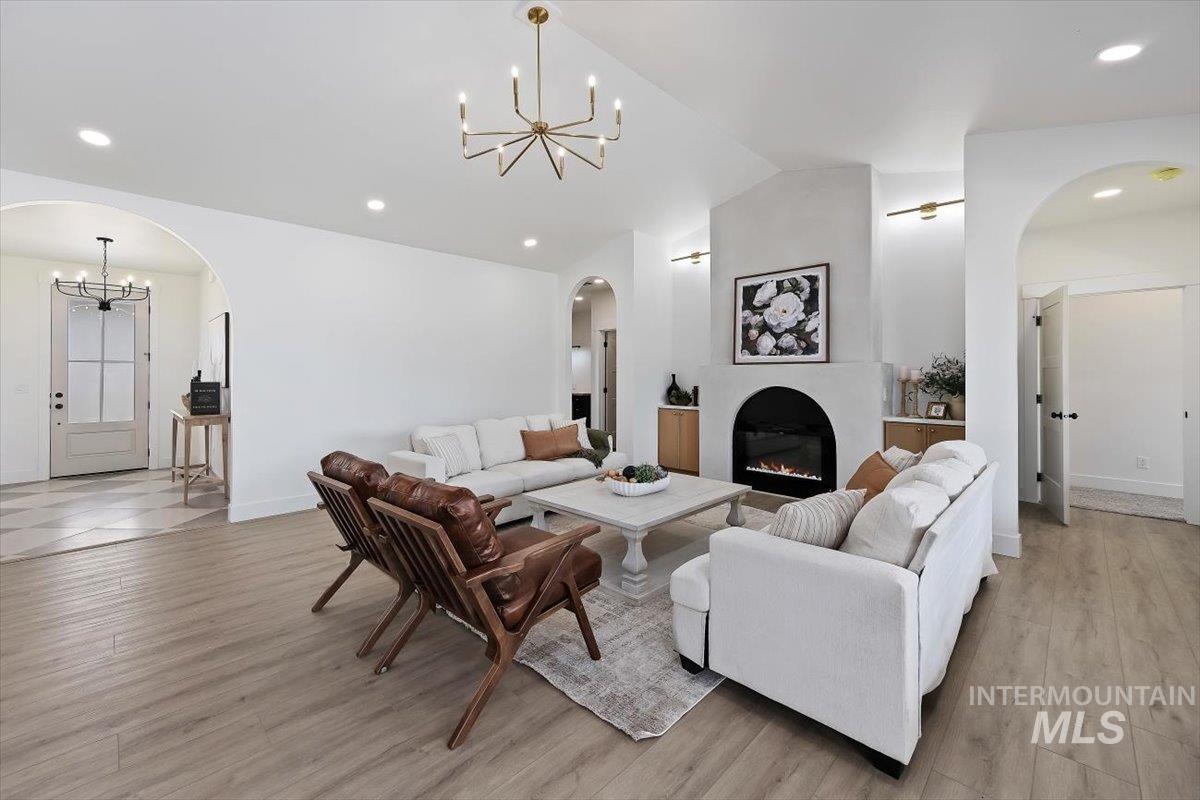 2005 Sparrow Street Rupert, ID 83350 - Photo 4 of 30 Spacious living area featuring a modern electric fireplace with an arched opening, recessed lighting, and a contemporary chandelier