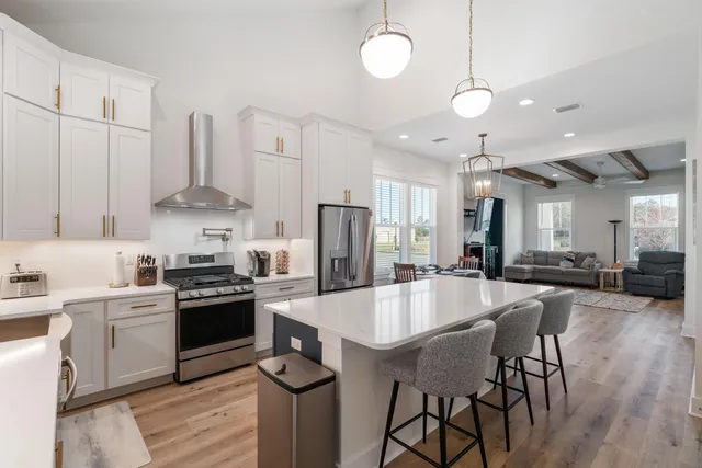 a large white kitchen with a sink and refrigerator