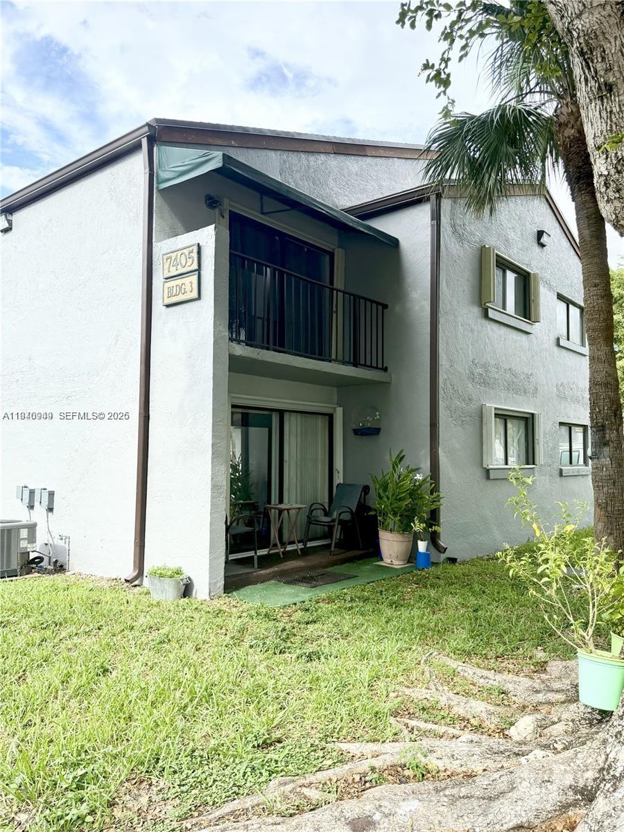 7405 Southwest 152nd Avenue, Unit 105 Miami, FL 33193 - Photo 2 of 9 a view of a house with potted plants and a large tree