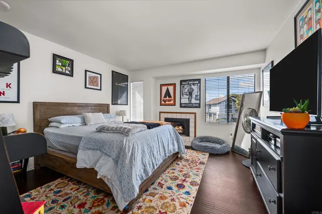 a bedroom with a bed a flat screen tv and dresser