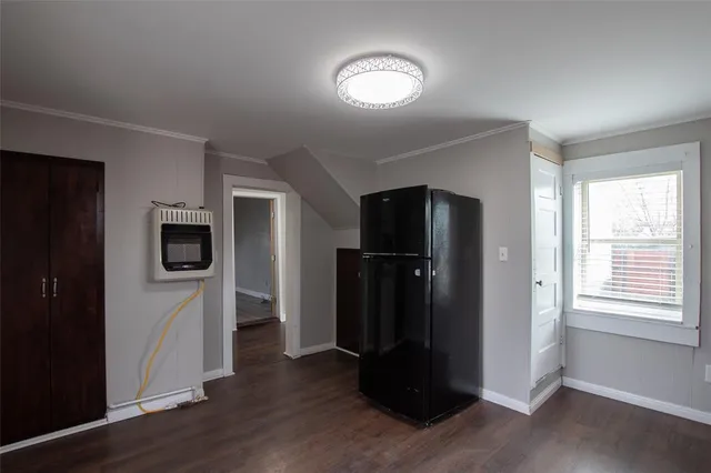 a view of a livingroom with a space walk in closet and wooden floor