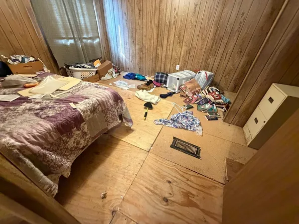 a bed sitting in a bedroom next to a window