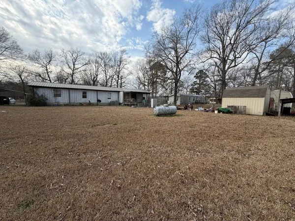 a view of a house with a yard and wooden fence