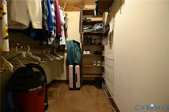 a view of walk in closet with clothes and shoes