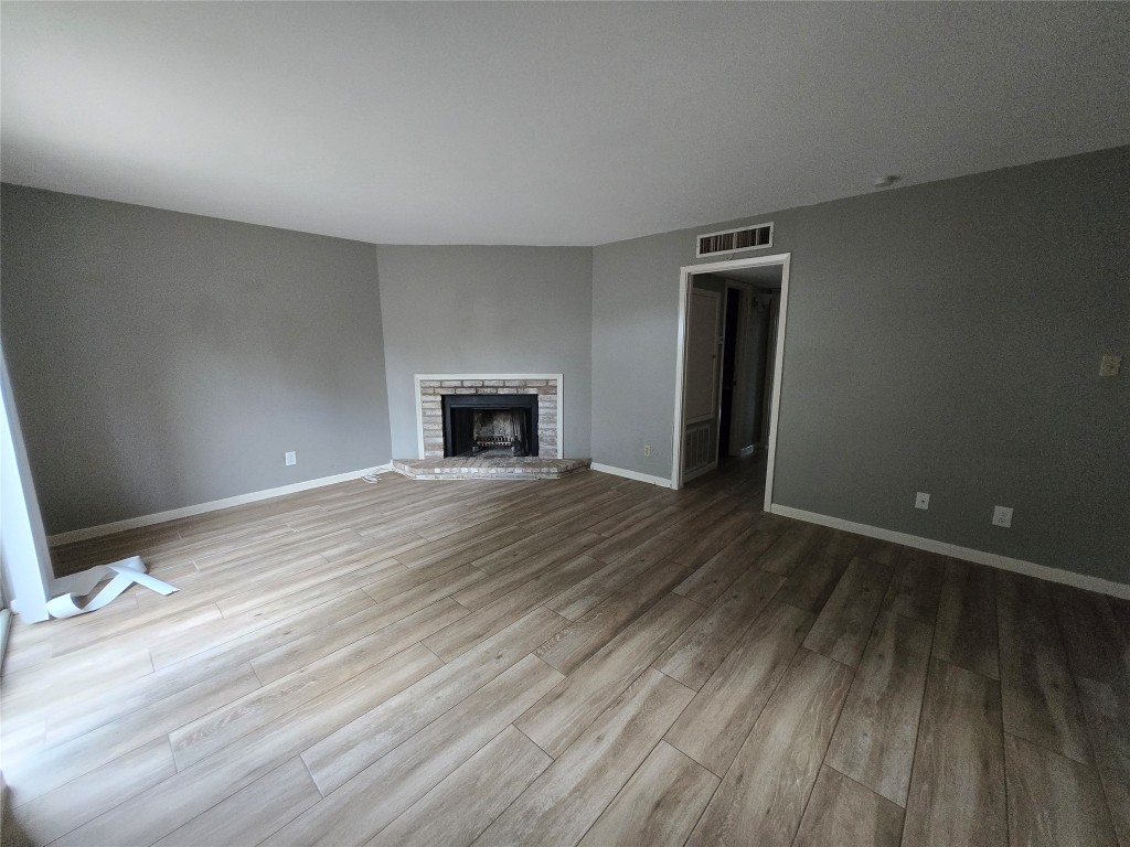 6401 Deihl Road, Unit 1006 Houston, TX 77092 - Photo 10 of 19 a view of empty room with wooden floor and fireplace