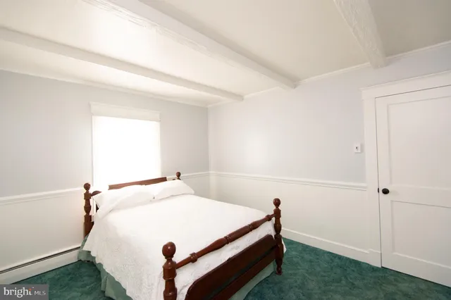 a bedroom with a bed and a wall painting