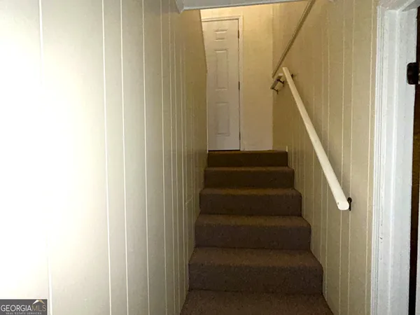 a view of staircase with lots of frames on wall
