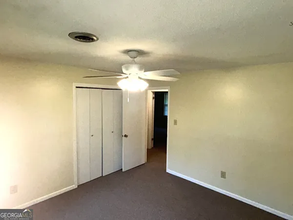 an empty room with a bathroom and a shower