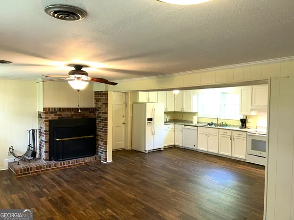 a large kitchen with kitchen island a sink dishwasher a stove and a refrigerator with wooden floor