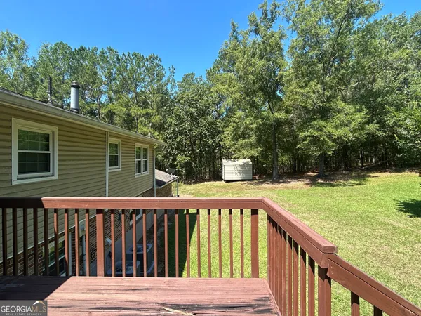 a view of a wooden deck and a yard with swimming pool