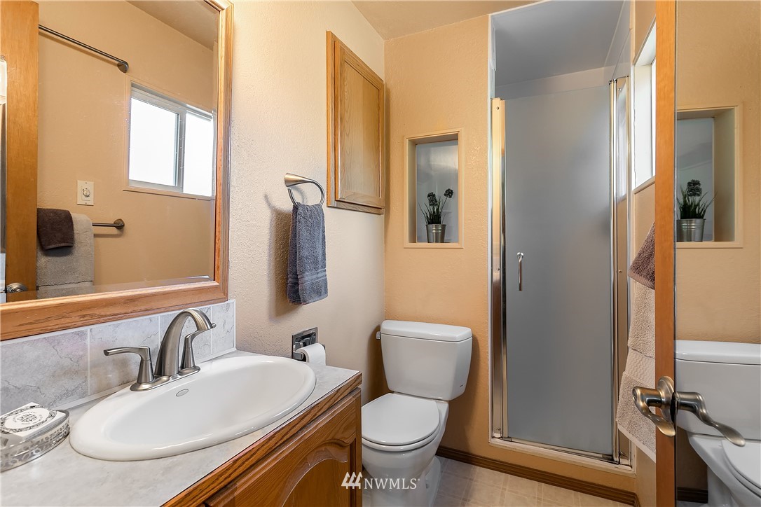 16404 Southeast 135th Street Renton, WA 98059 - Photo 15 of 22 a bathroom with a granite countertop toilet sink and a mirror