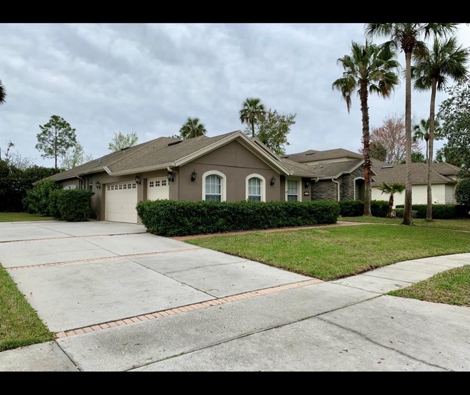 761 Broadoak Loop Sanford, FL 32771 - Photo 2 of 22 a front view of a house with a garden and palm trees