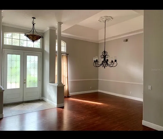 a view of a livingroom with wooden floor and a floor to ceiling window