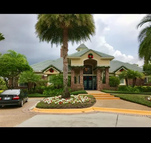 a front view of a house with a garden and car parked