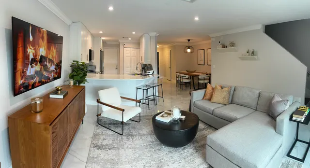 a living room with furniture a rug and a painting