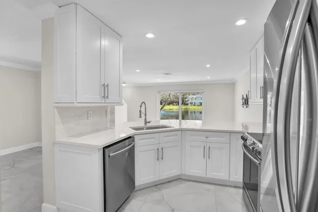 a kitchen with white cabinets stainless steel appliances and sink