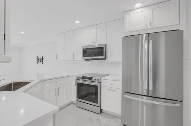 a kitchen with white cabinets and stainless steel appliances