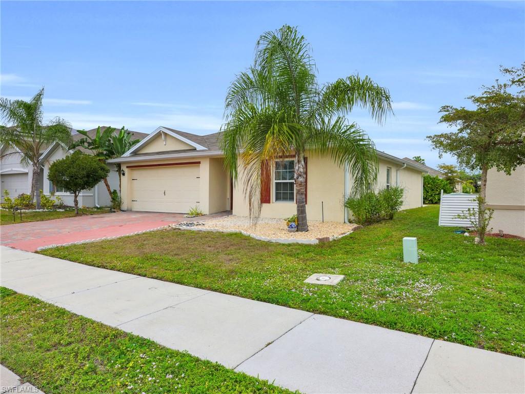 731 Hadley Place West Naples, FL 34104 - Photo 27 of 30 Front Angled View of 731 Hadley Place W With Right Side Yard View And Widened Driveway