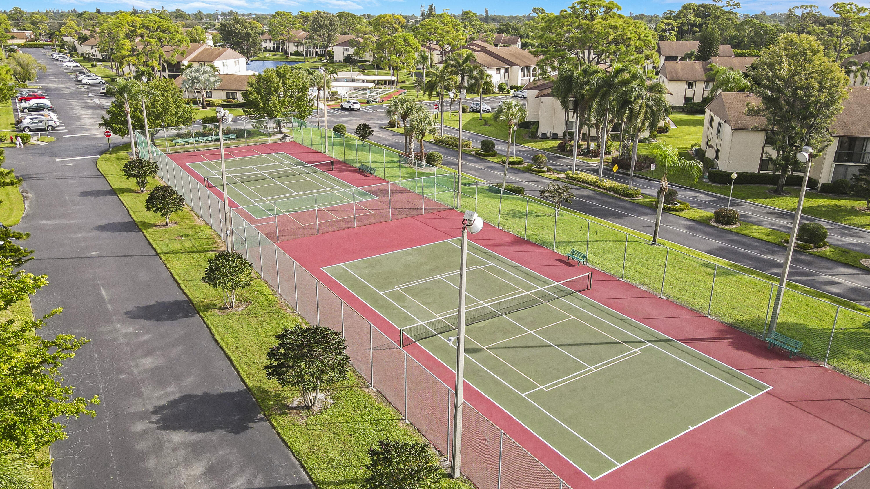 335 Knotty Pine Circle, Unit D1 Greenacres, FL 33463 - Photo 16 of 18 an aerial view of a tennis ground with large trees