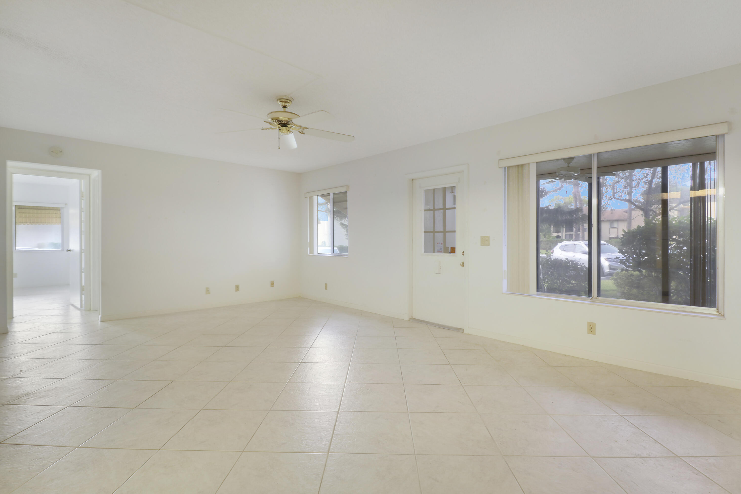 335 Knotty Pine Circle, Unit D1 Greenacres, FL 33463 - Photo 4 of 18 an empty room with chandelier fan and windows