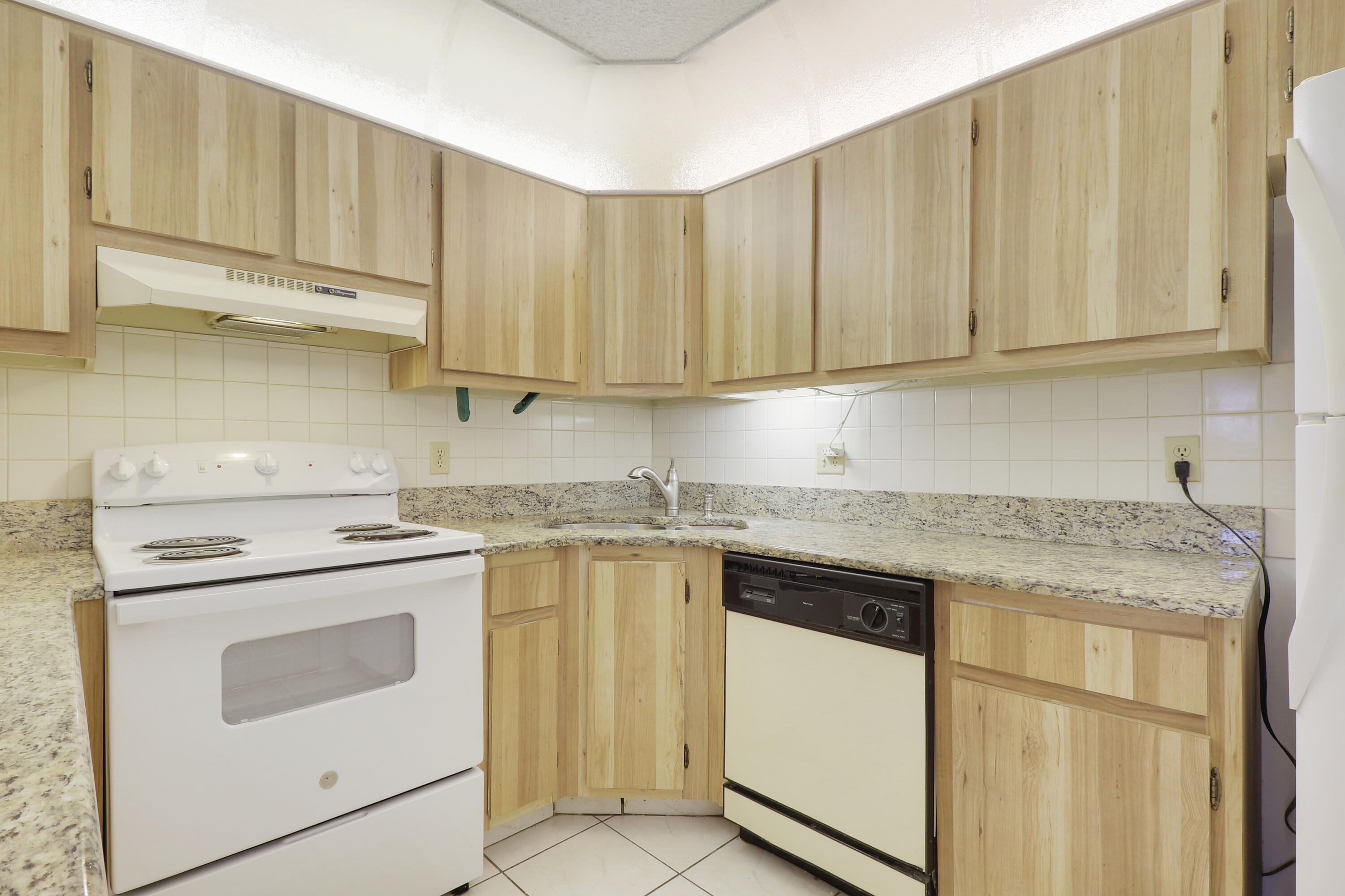 335 Knotty Pine Circle, Unit D1 Greenacres, FL 33463 - Photo 5 of 18 a kitchen with granite countertop cabinets stainless steel appliances and a sink