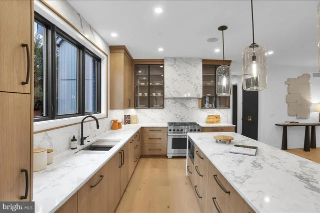 a large kitchen with stainless steel appliances kitchen island granite countertop a sink stove and refrigerator