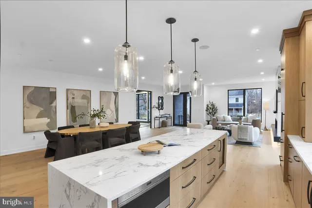 a large kitchen with sink a counter and chairs