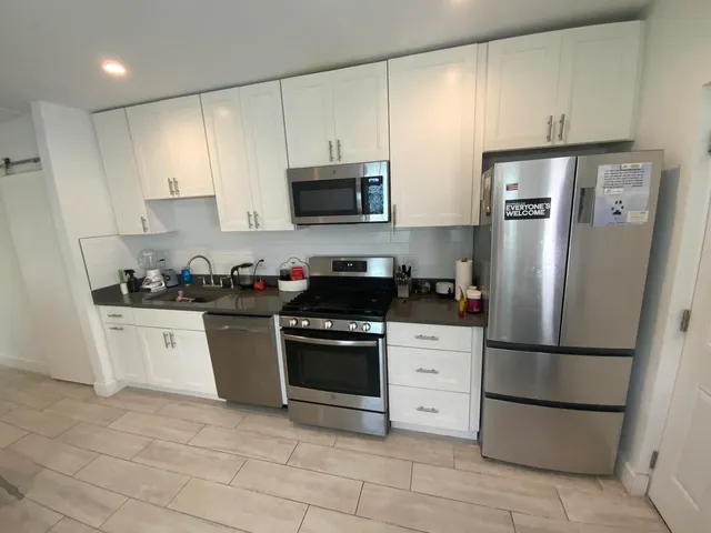 a kitchen with stainless steel appliances granite countertop a refrigerator stove a sink and dishwasher