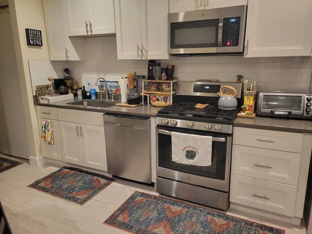 a kitchen with stainless steel appliances granite countertop a stove a microwave and cabinets