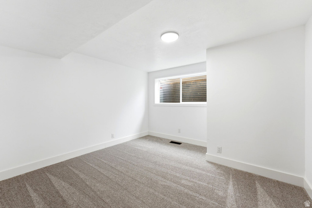 871 Bonita Way Centerville, UT 84014 - Photo 29 of 61 Carpeted room featuring a window with a window well, white walls, and a ceiling-mounted light fixture