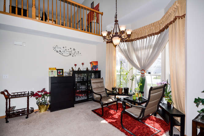 796 Teasel Lane Aurora, IL 60504 - Photo 11 of 37 a living room with furniture a fireplace and a chandelier