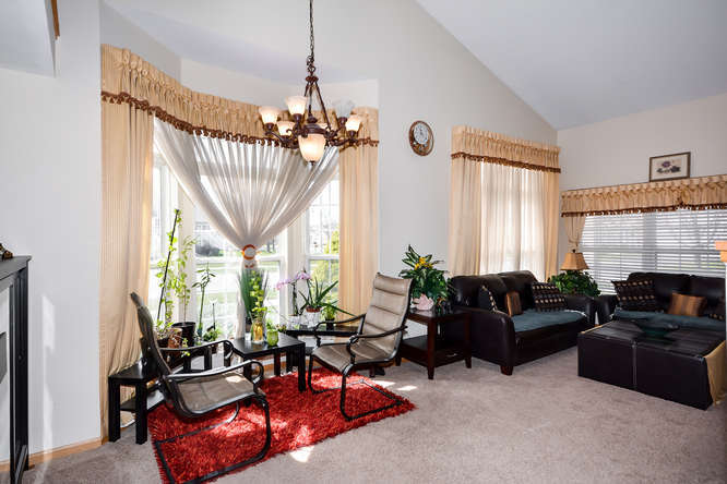 796 Teasel Lane Aurora, IL 60504 - Photo 13 of 37 a living room with furniture a chandelier and a fireplace