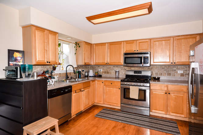 796 Teasel Lane Aurora, IL 60504 - Photo 2 of 37 a kitchen with stainless steel appliances a stove sink and microwave