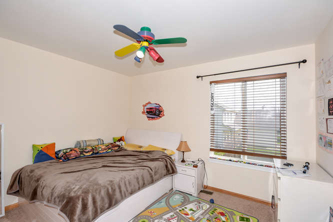 796 Teasel Lane Aurora, IL 60504 - Photo 24 of 37 a bedroom with a bed and a chandelier