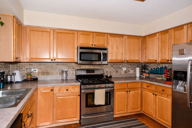 796 Teasel Lane Aurora, IL 60504 - Photo 3 of 37 a kitchen with granite countertop a stove top oven microwave and cabinets